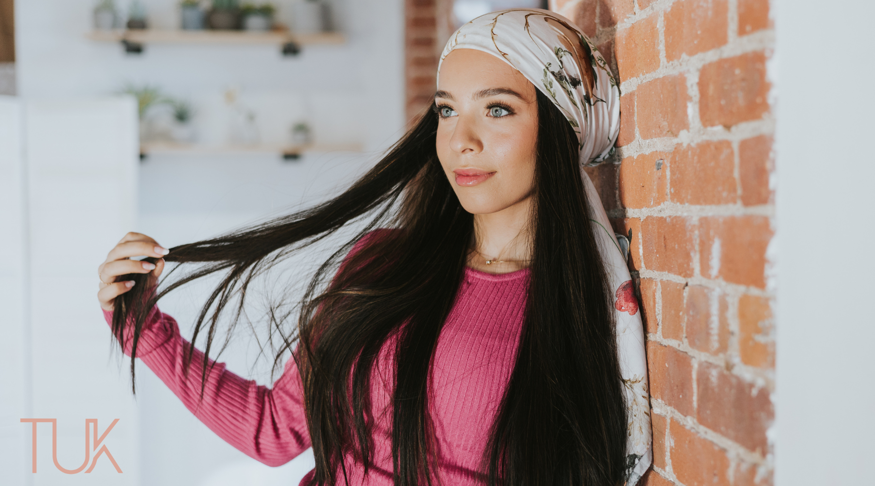 Woman wearing a headscarf and playing with her hair