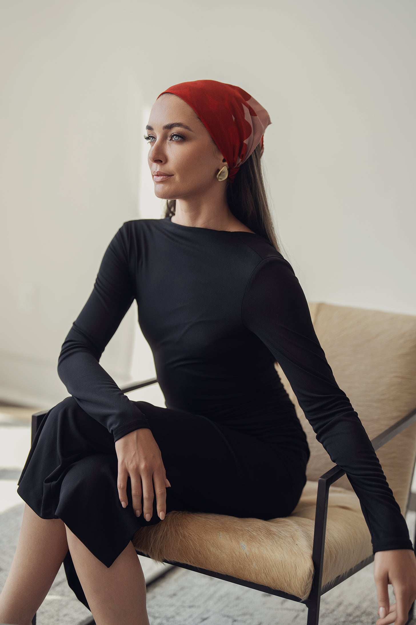 Red and blush pink bandana with abstract floral patterns, styled as a headwrap, adding a bold yet elegant accent to the outfit.