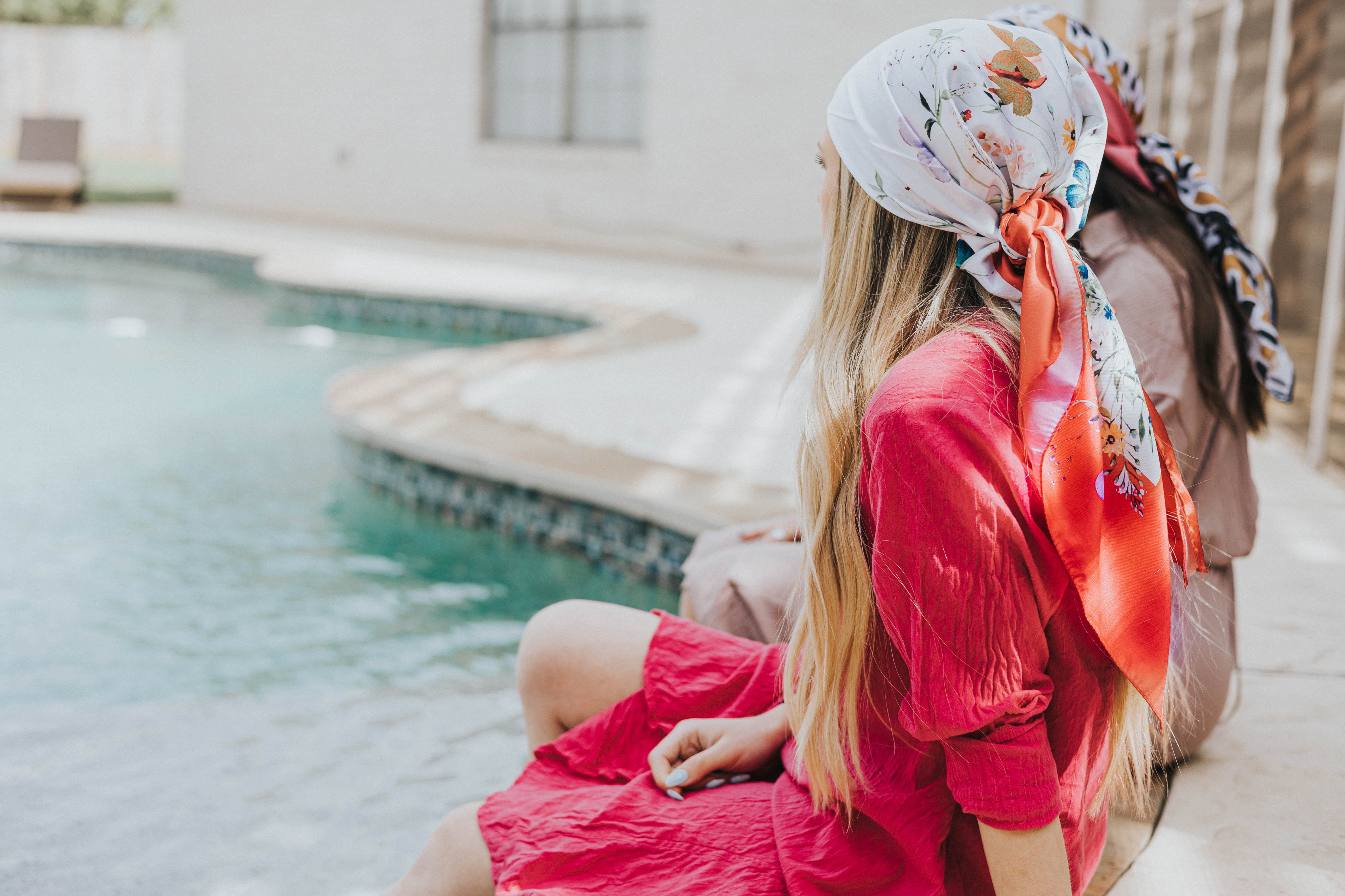 2 women sitting poolside wearing head scarves for women