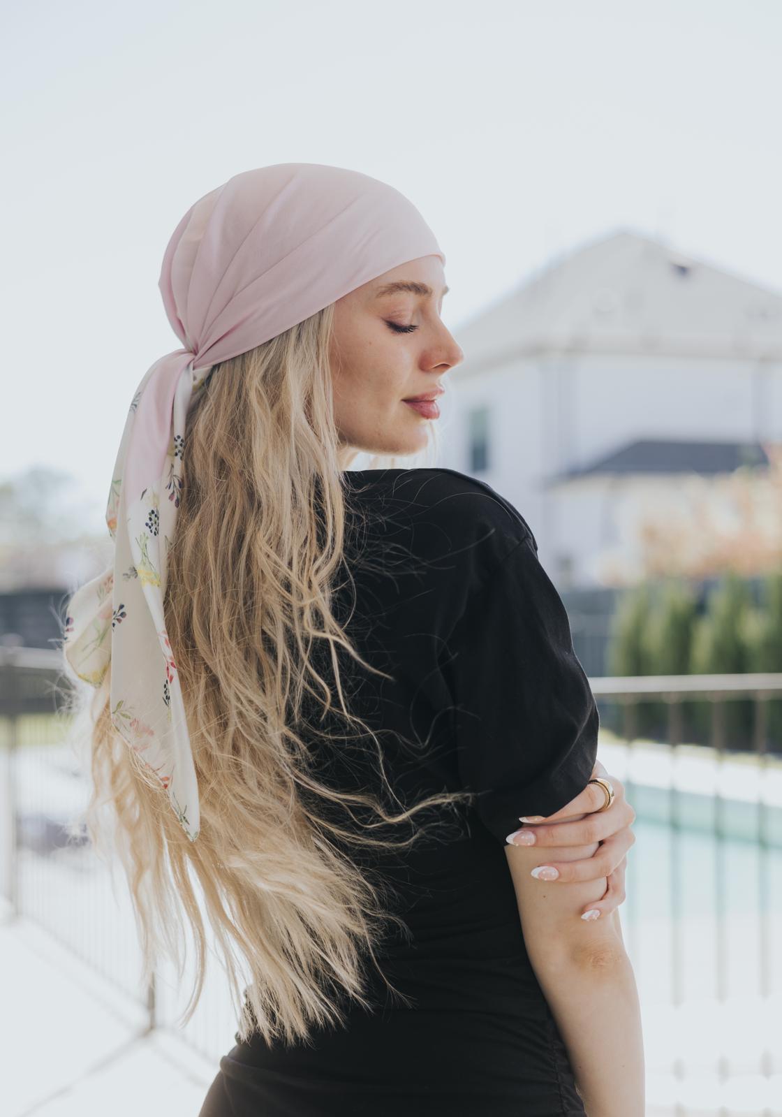 Featuring a soft blush pink base paired with an airy white silk tail adorned in watercolor floral prints, this scarf captures the essence of springtime grace. 